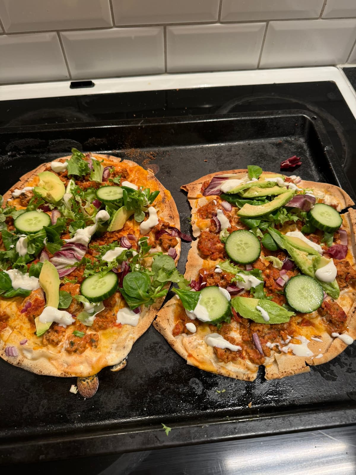 Två tortillapizzor med avokado, gurka och sallad